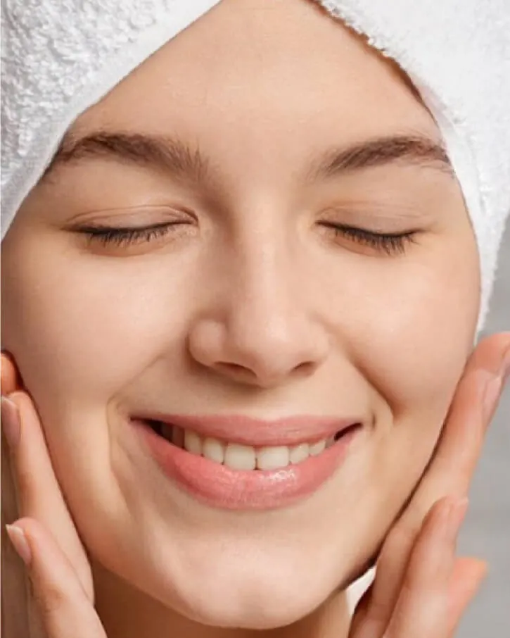 Model berhanduk di kepala memejamkan mata sambil menepuk pipi