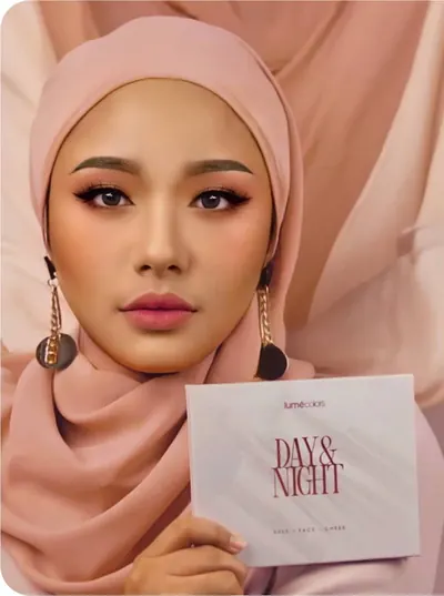 Model berhijab dusty pink dengan anting emas memegang kotak Day & Night