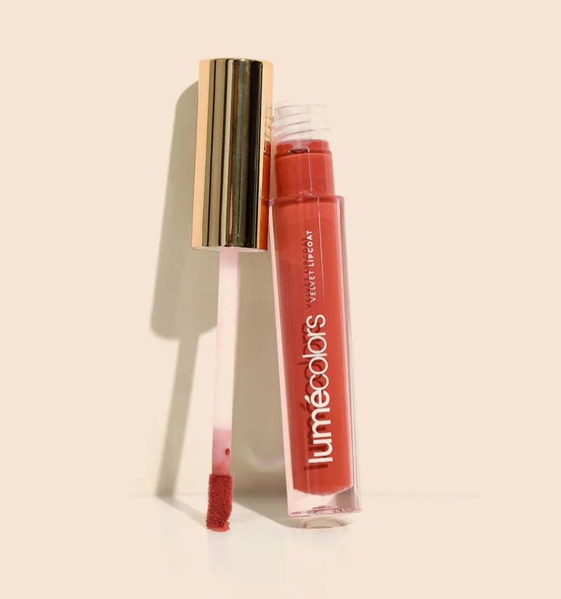 Tube Lumécolors Velvet Lipcoat merah bata dengan aplikator doe-foot berdiri di sampingnya