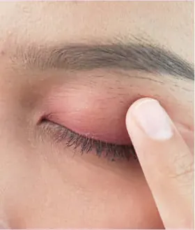 Ujung jari menekan kelopak mata ber-eyeshadow pink