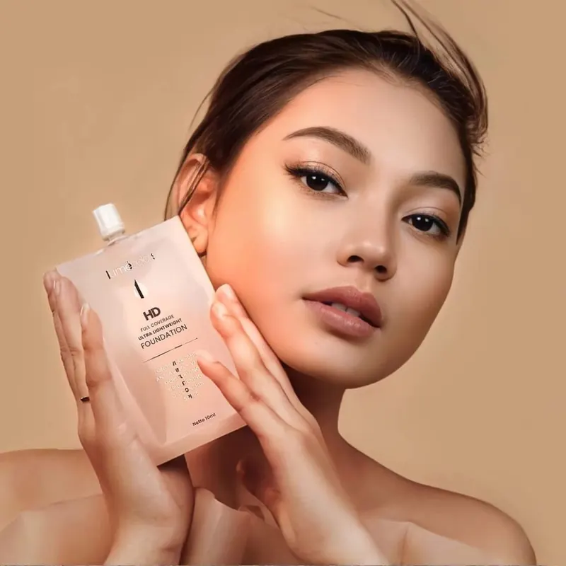 Model memegang kemasan HD Foundation Lumécolors